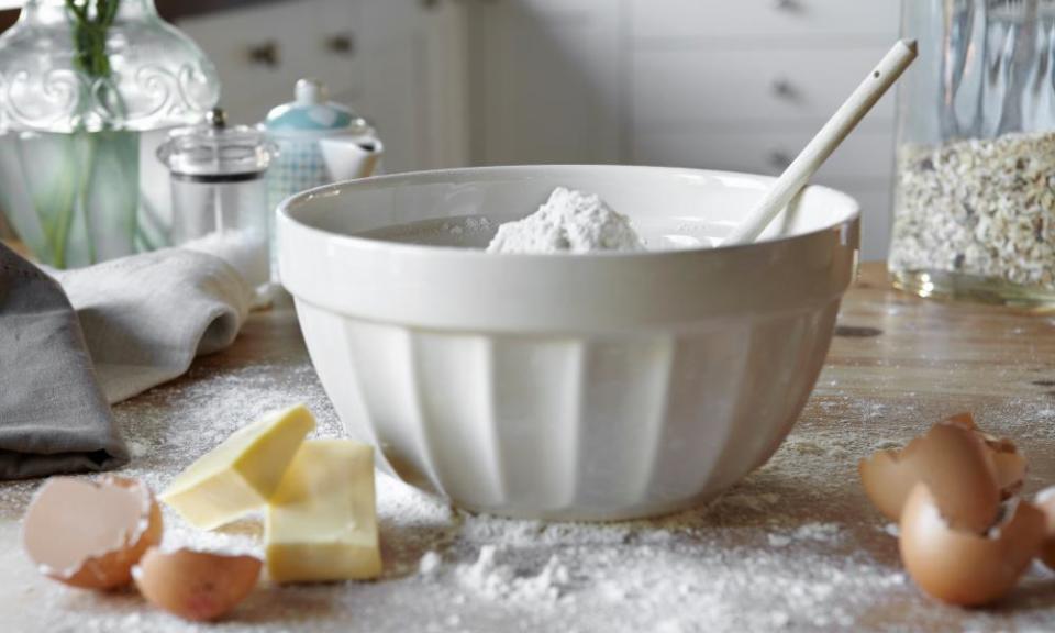 Bowl of mixing dough in messy kitchen.