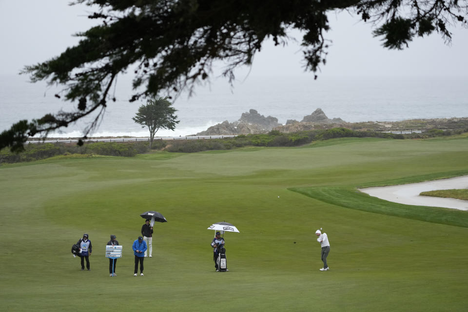 Harrison Endycott, right, hits his approach shot up to the 10th green of the Monterey Peninsula Country Club Shore Course during the second round of the AT&T Pebble Beach Pro-Am golf tournament in Pebble Beach, Calif., Friday, Feb. 3, 2023. (AP Photo/Eric Risberg)