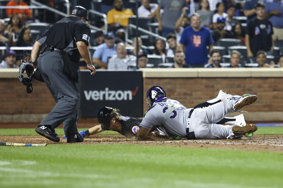 Colorado Rockies catcher Elias Diaz (35) tags New York Mets' Jeff McNeil out at home during the sixth inning of a baseball game on Friday, Aug. 26, 2022, in New York. (AP Photo/Jessie Alcheh)