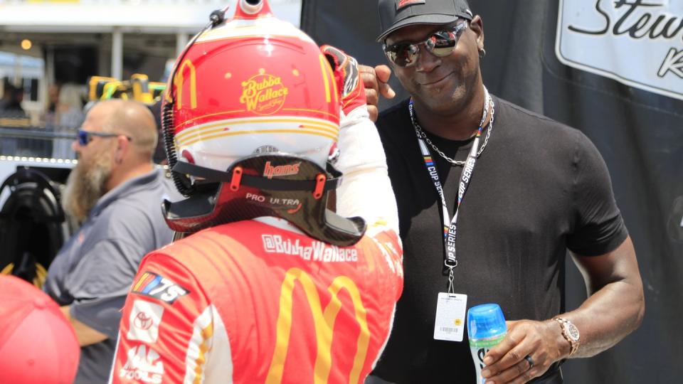 michael jordan giving a fist bump to his nascar driver bubba wallace on nascar pit road