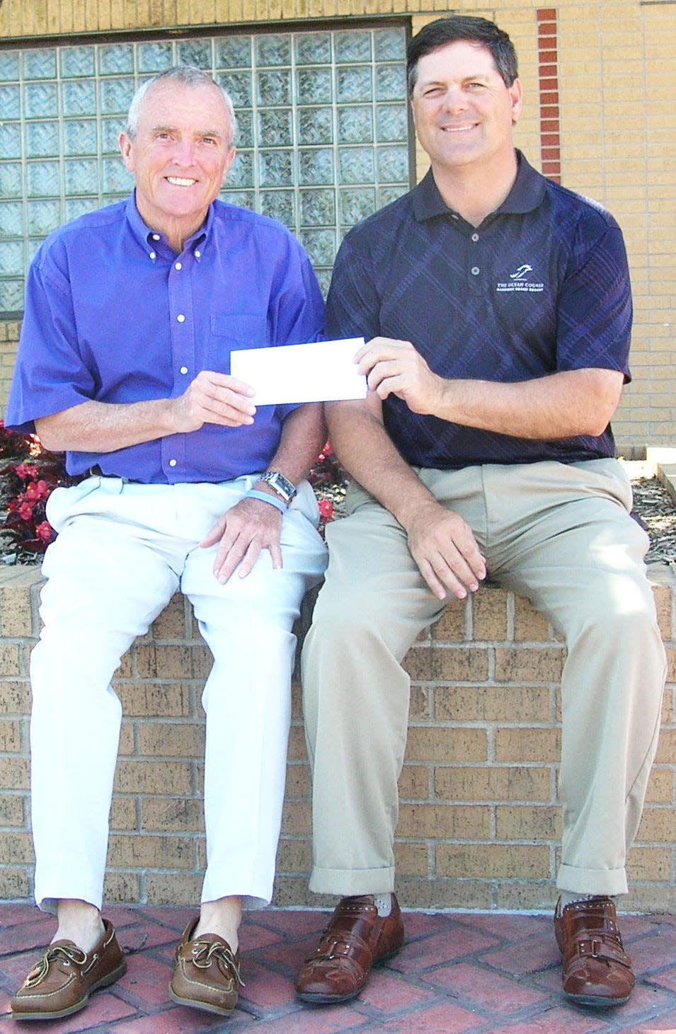 Several years ago, Bob Pomeroy, left, of the Bartlesville Sports Commission presents Bartlesville High head girls golf coach Terry Hughes with some financial support for the golf program.