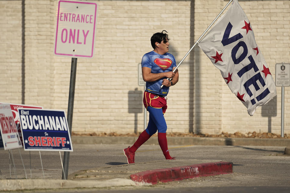 Dressed as Superman and holding a 