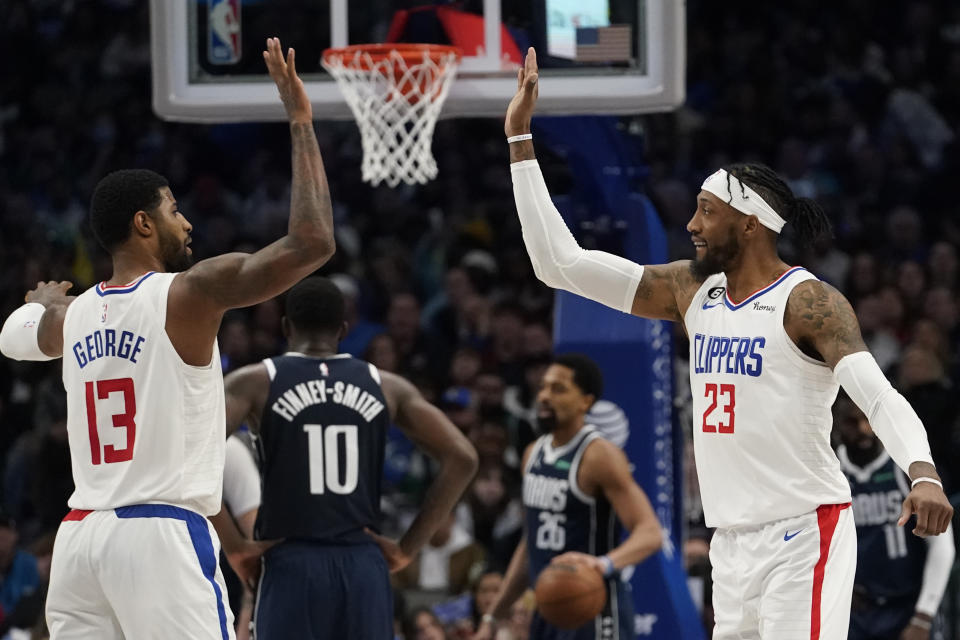Los Angeles Clippers forward Robert Covington (23) and guard Paul George (13) celebrate a play during the second half of an NBA basketball game in Dallas, Sunday, Jan. 22, 2023. The Clippers won 112-98. (AP Photo/LM Otero)