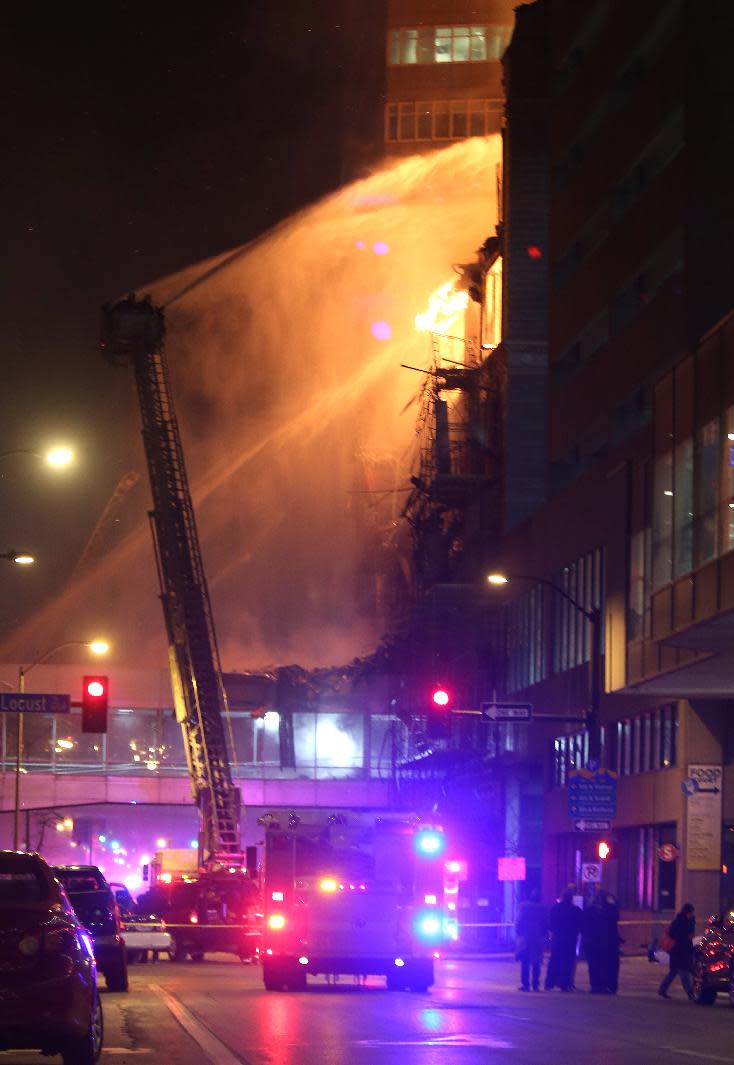 Fire crews from Des Moines work to control a fire at the Younkers building in downtown Des Moines, Iowa early Saturday, March 29, 2014. The massive fire swept through a century-old building that was being renovated, causing its upper floors to collapse and authorities to close down numerous streets in downtown Des Moines. No one was injured. Des Moines Fire Department spokesman Brian O'Keefe said it first got word of a fire at the former Younkers department store building at about 12:50 a.m. Saturday, and arrived to find flames leaping from the upper floors of the seven-floor building, which dates to 1899. (AP Photo/The Des Moines Register, Bryon Houlgrave) MANDATORY CREDIT THE DES MOINES REGISTER BRYON HOULGRAVE