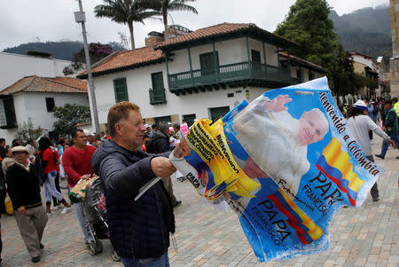 A man sells flags with images of Pope Francis outside the Cathedral of Bogota in Bolivar Square, Colombia September 2, 2017. REUTERS/Henry Romero