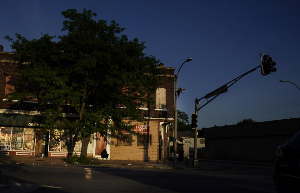 A person sits on a door stoop near downtown St. Louis on Thursday, May 20, 2021. (AP Photo/Brynn Anderson)