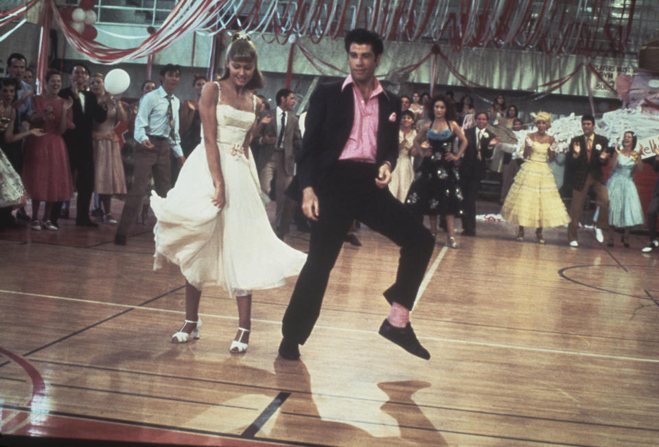 Olivia Newton-John and John Travolta dance in a crowded high school gym in Grease.