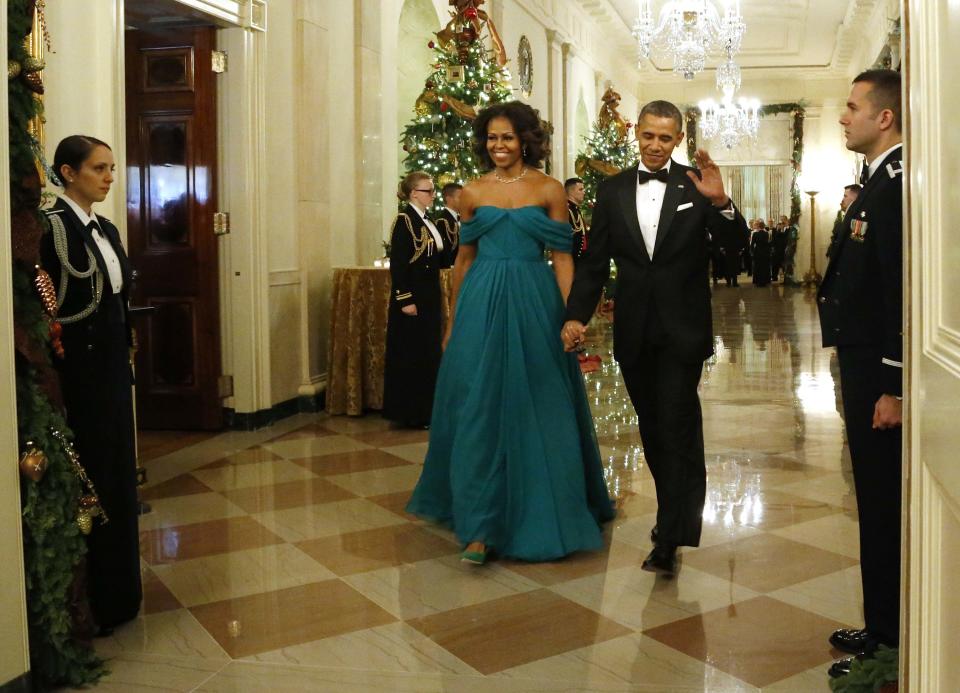 U.S. President Barack Obama waves as he and first lady Michelle Obama arrive for a reception for the 2013 Kennedy Center Honors recipients at the White House in Washington
