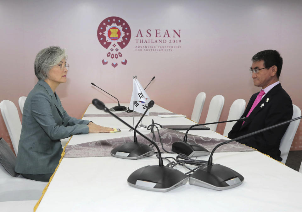 Japanese Foreign Minister Taro Kono, right, and his South Korean counterpart Kang Kyung-wha sit at a table for a bilateral meeting on the sidelines of the ASEAN Foreign Ministers Meetings in Bangkok, Thailand, Thursday, Aug. 1, 2019. (Lee Jung-hoon/Yonhap via AP)