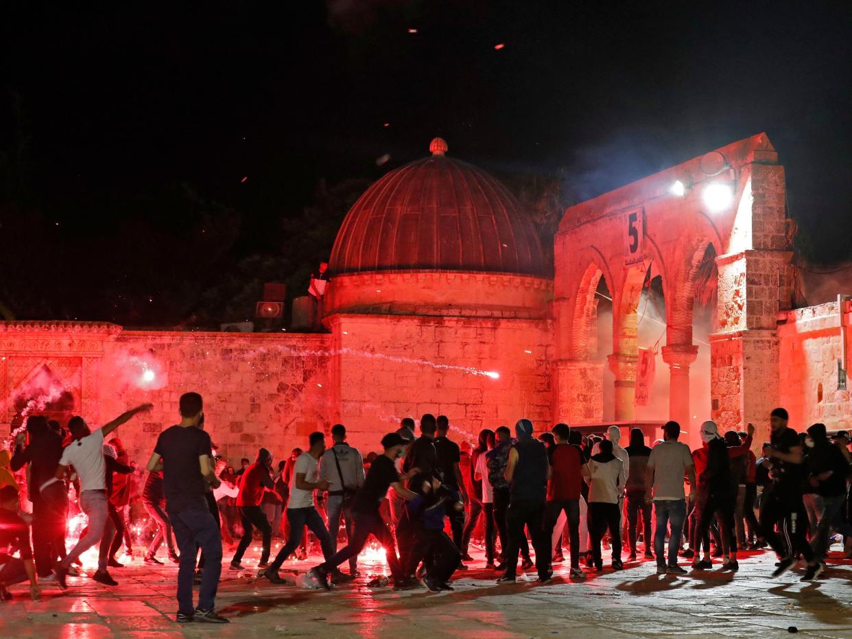 Palestinian protesters hurl flares amid clashes with Israeli security forces at the al-Aqsa mosque.