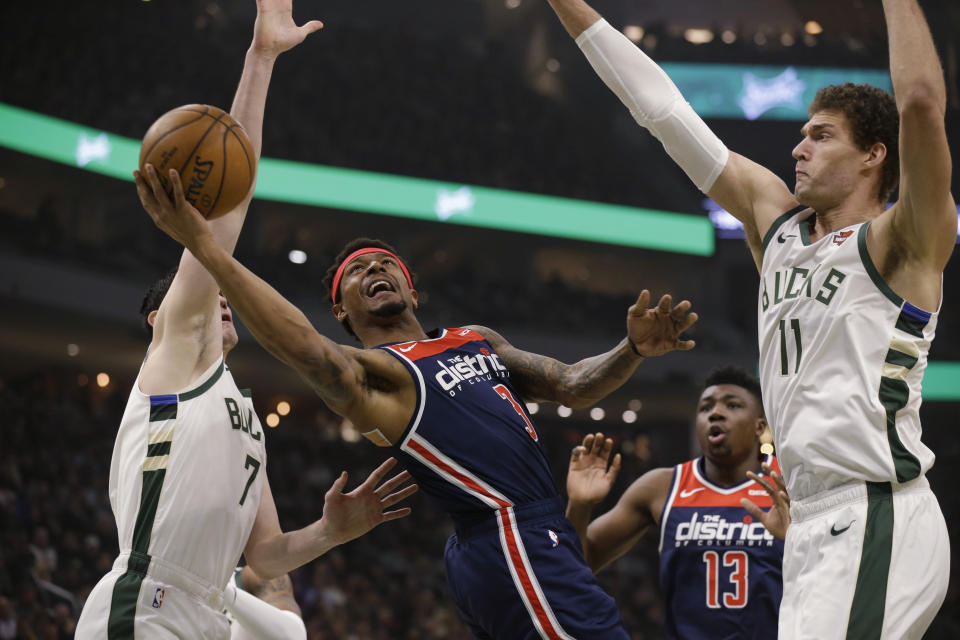 Washington Wizards' Bradley Beal (3) shoots between Milwaukee Bucks' Ersan Ilyasova, left, and Brook Lopez during the first half of an NBA basketball game Tuesday, Jan. 28. 2020, in Milwaukee. (AP Photo/Jeffrey Phelps)