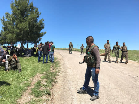 Kurdish fighters from the People's Protection Units (YPG) gather near their headquarters after it was hit by Turkish airstrikes in Mount Karachok near Malikiya, Syria, April 25, 2017. REUTERS/Rodi Said