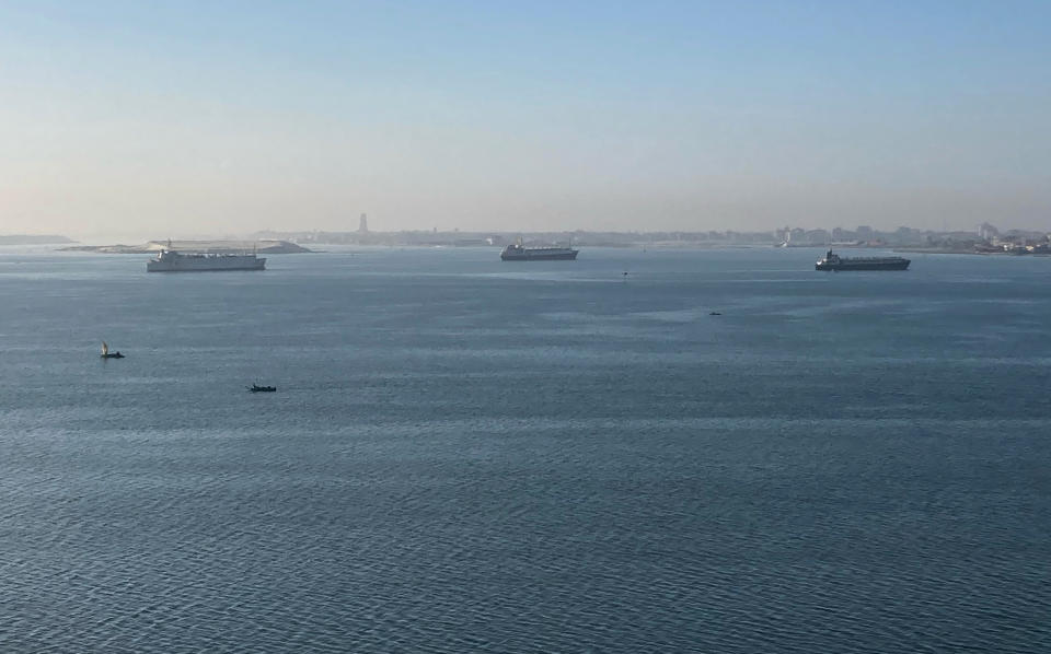 Desde tierra, se pueden observar los cargeros acumulados junto a la entrada del Canal de Suez a la espera de poder proseguir su camino. Bloomberg calcula que en estos momentos hay unos 300 barcos parados. Foto: Associated Press/ Sam Magdy.