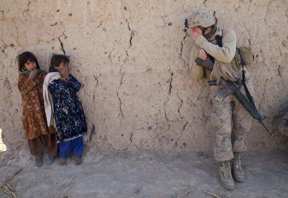 BOLDOC, AFGHANISTAN - NOVEMBER 23: Corporal Catherine Broussard, 22, a US Marine with the FET ( Female Engagement Team) 1st Battalion 8th Marines, Regimental Combat team II tries to communicate with some Afghan girls, during a village medical outreach November 23, 2010 in Boldoc, in Helmand province , Afghanistan. There are 48 women presently working along the volatile front lines of the war in Afghanistan; deployed as the second Female Engagement team participating in a more active role, gaining access where men can't. The women, many who volunteer for the 6.5 month deployment, take a 10 week course at Camp Pendleton in California where they are trained for any possible situation, including learning Afghan customs and basic Pashtun language. (Photo by Paula Bronstein /Getty Images)