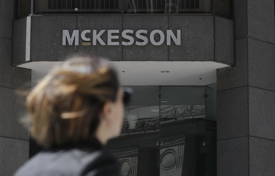 FILE - In this July 17, 2019 file photo, a pedestrian passes a McKesson sign on an office building in San Francisco. At least a half-dozen companies that make or distribute prescription opioid painkillers are facing a federal criminal investigation of their roles in a nationwide addiction and overdose crisis. The Wall Street Journal first reported the investigation Tuesday, Nov. 26, 2019, citing unnamed sources familiar with the probe. (AP Photo/Jeff Chiu, File)