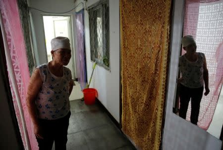 Huang is reflected in a mirror as she stands in front of her room at the accommodation where some patients and their family members stay while seeking medical treatments in Beijing, China, June 22, 2016. REUTERS/Kim Kyung-Hoon