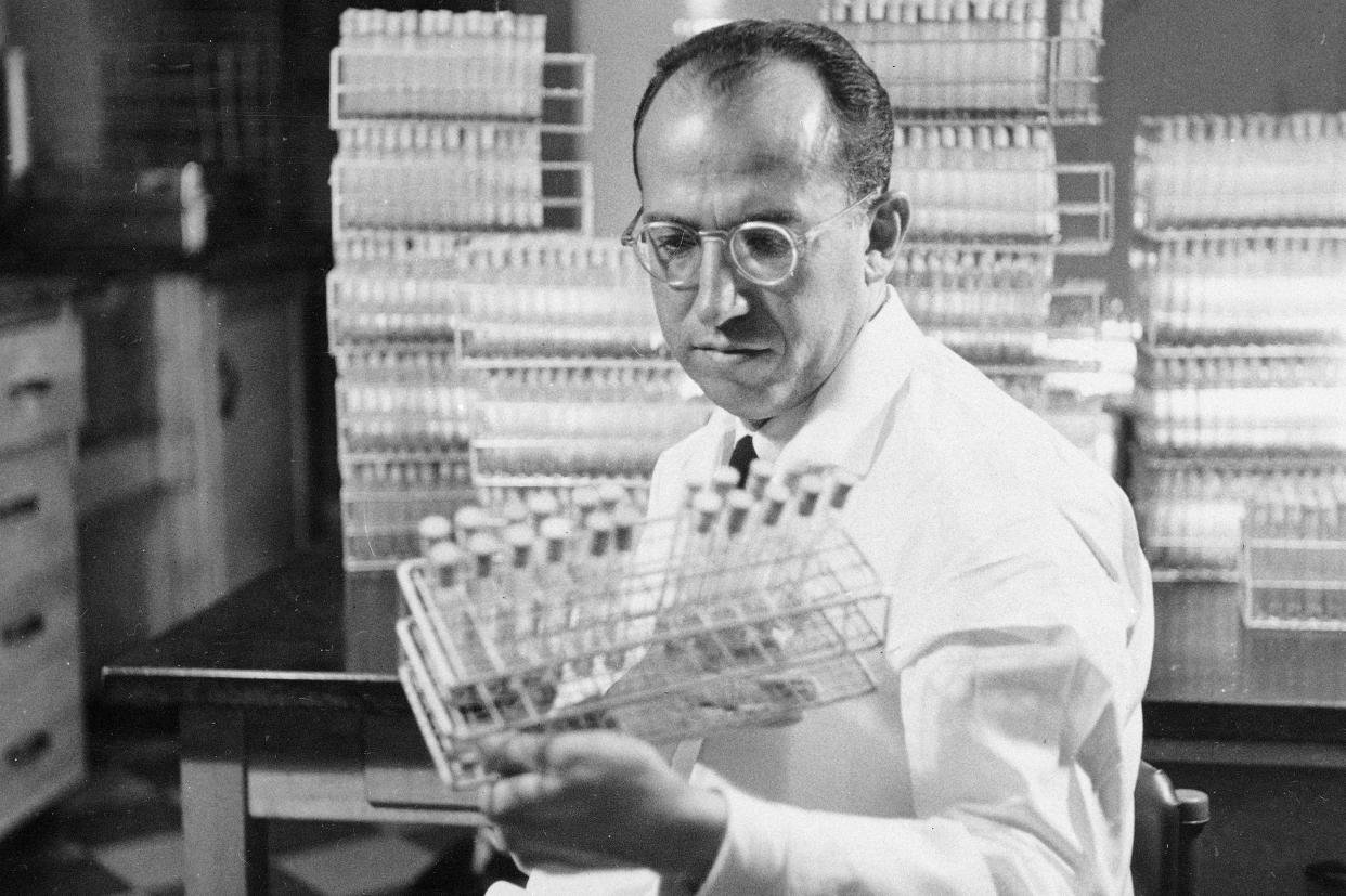 FILE - In this Oct. 7, 1954, file photo, Dr. Jonas Salk, developer of the polio vaccine, holds a rack of test tubes in his lab in Pittsburgh. 