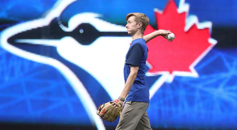 TORONTO, CANADA - AUGUST 14: Braden Halladay the son of former player Roy Halladay #32 of the Toronto Blue Jays plays catch in the outfield after the game before which his father was honored at the fortieth season celebrations before the start of MLB game action against the Houston Astros on August 14, 2016 at Rogers Centre in Toronto, Ontario, Canada. (Photo by Tom Szczerbowski/Getty Images)