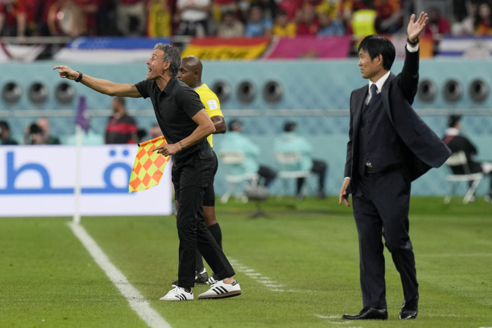 Spain's head coach Luis Enrique, left, and Japan's head coach Hajime Moriyasu, right, instruct their players during a World Cup group E soccer match at the Khalifa International Stadium in Doha, Qatar, Thursday, Dec. 1, 2022. (AP Photo/Eugene Hoshiko)