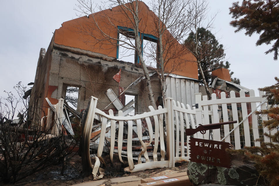 Two packages sit in the driveway of the home that Jeanne and Mike Welnick owned outside Flagstaff, Ariz., on Tuesday, April 26, 2022. A massive wildfire that started Easter Sunday burned about 30 square miles and more than a dozen homes, hopscotching across the parched landscape. (AP Photo/Felicia Fonseca)