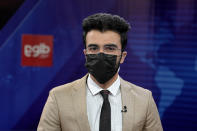 TV anchor Hamed Bahram wears a face mask to protest the Taliban's new order that female presenters cover their faces as he reads the news on TOLOnews, in Kabul, Afghanistan, Sunday, May 22, 2022. Afghanistan's Taliban rulers have begun enforcing an order requiring all female TV news anchors in the country to cover their faces while on-air. The move Sunday is part of a hard-line shift drawing condemnation from rights activists. (AP Photo/Ebrahim Noroozi)