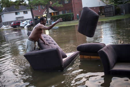 Vince Ware moves his sofas onto the sidewalk from his house which was left flooded from Tropical Storm Harvey in Houston, Texas. REUTERS/Adrees Latif