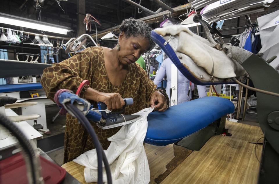 Vivian Bowers irons a shirt.