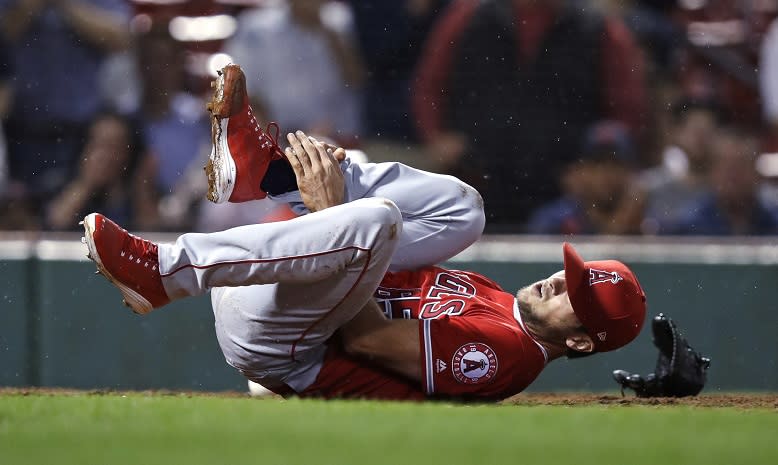 Los Angeles Angels’ pitcher Jake Jewell rolls on the field after injuring his right ankle while covering home during Wednesday’s game in Boston. (AP)