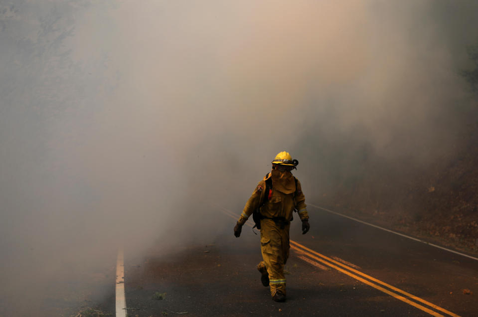 <p>Firefighters work to contain the Tubbs wildfire outside Calistoga, Calif., Oct. 12, 2017. (Photo: Jim Urquhart/Reuters) </p>