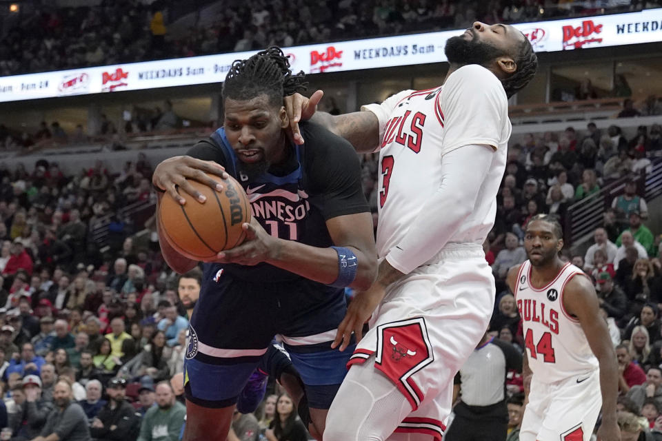 Minnesota Timberwolves center Naz Reid, left, pulls in a rebound next to Chicago Bulls center Andre Drummond during the first half of an NBA basketball game in Chicago, Friday, March 17, 2023. (AP Photo/Nam Y. Huh)