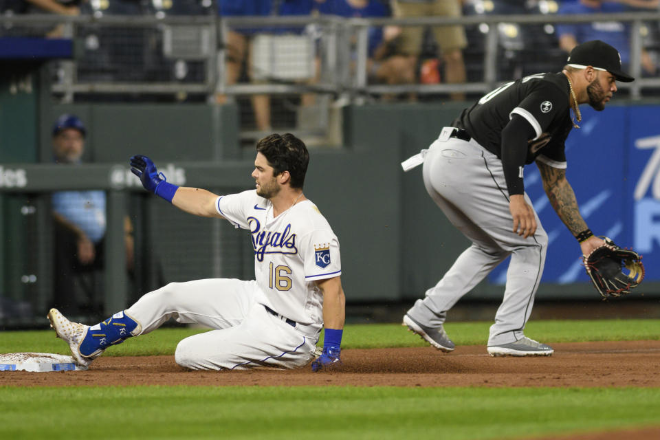 Kansas City Royals' Andrew Benintendi, left, is safe into third on a triple ahead of the throw to Chicago White Sox third baseman Yoan Moncada, right, during the second inning of a baseball game, Friday, Sept. 3, 2021, in Kansas City, Mo. (AP Photo/Reed Hoffmann)