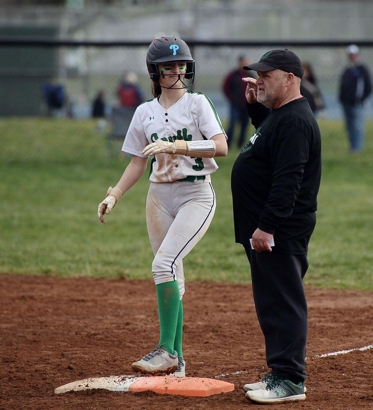 South Hagerstown's Bethany Higgins talks with first base coach Paul Showe during the Rebels' 19-1 softball win over North Hagerstown.