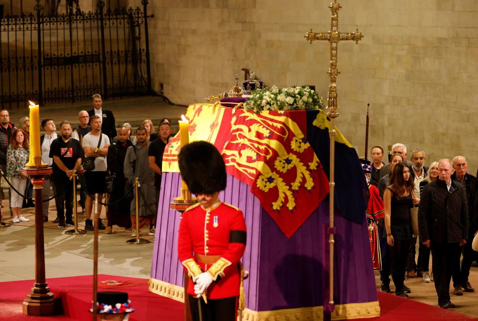 Members of the public pay their respects as they pass the coffin of Queen Elizabeth II, draped in the Royal Standard with the Imperial State Crown and the Sovereign's orb and sceptre, lying in state on the catafalque in Westminster Hall, at the Palace of Westminster, ahead of her funeral on Monday, on September 15, 2022 in London, England.