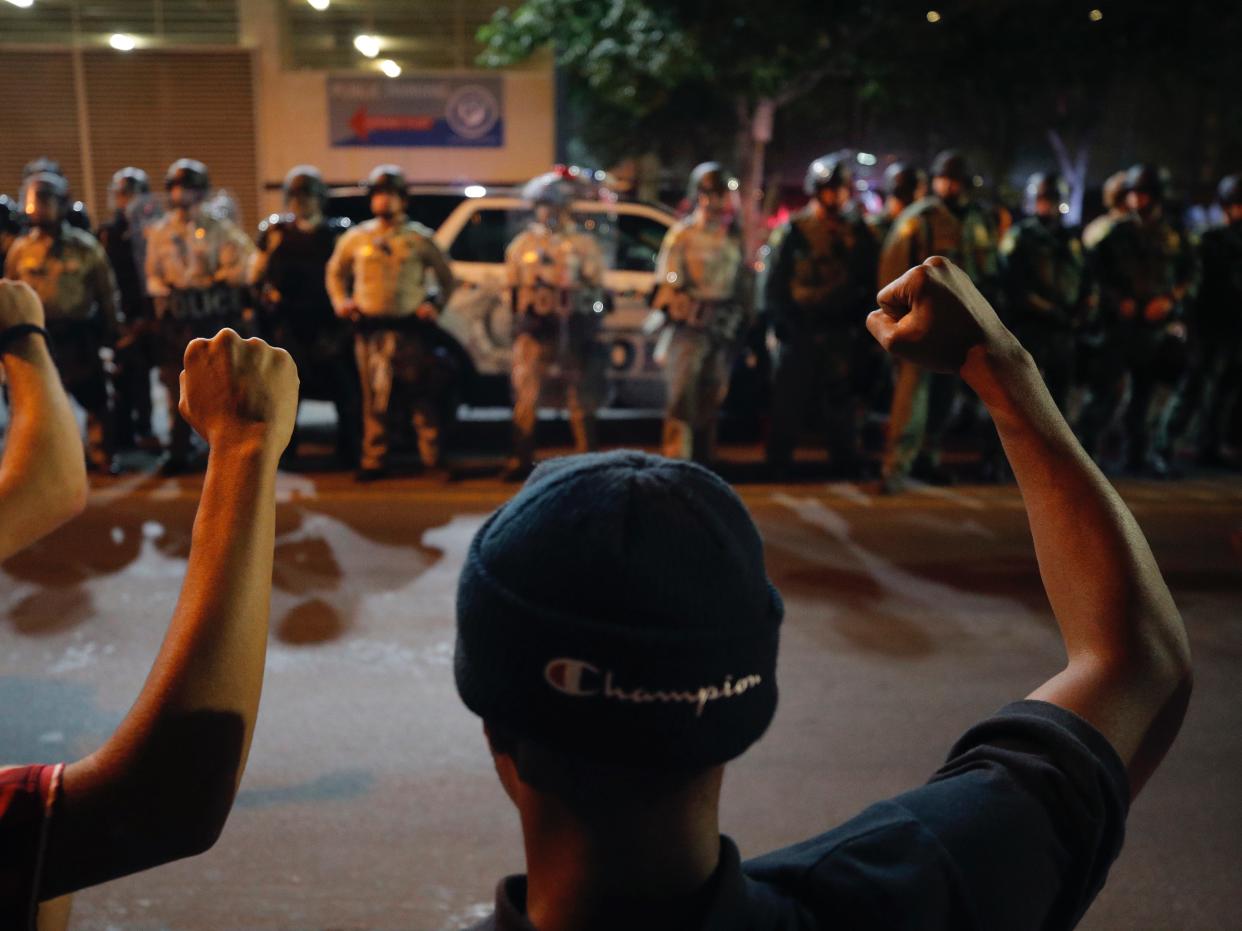 Protesters raise their fists during a rally Monday, June 1, 2020, in Las Vegas, over the death of George Floyd, a black man who was in police custody in Minneapolis. (AP Photo/John Locher)