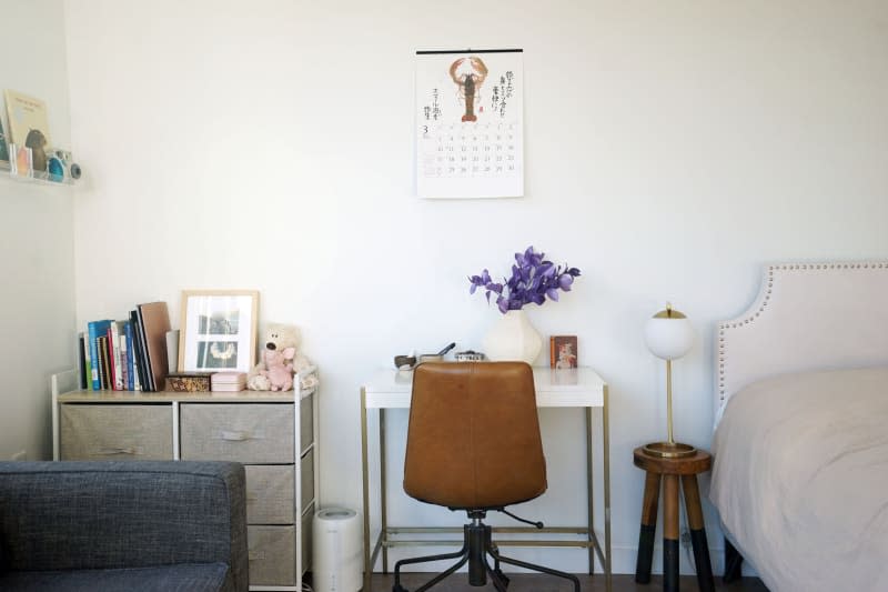 A leather office chair sits under a white and gold desk chair.