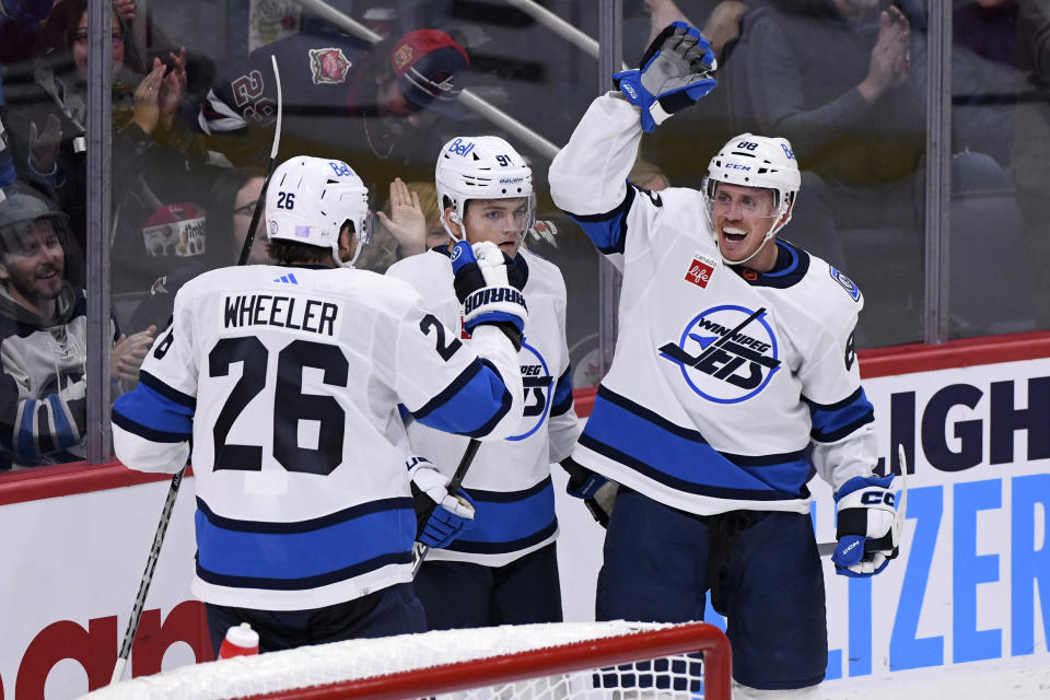Winnipeg Jets' Nate Schmidt (88) celebrates his goal against the Chicago Blackhawks with Blake Wheeler (26) and Cole Perfetti (91) during the third period of an NHL hockey game in Winnipeg, Manitoba, Saturday, Nov. 5, 2022. (Fred Greenslade/The Canadian Press via AP)