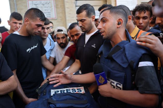 Mourners and colleagues surround the body of Al-Jazeera Arabic journalist Ismail al-Ghoul, killed along with his cameraman Rami al-Rifi in an Israeli strike.