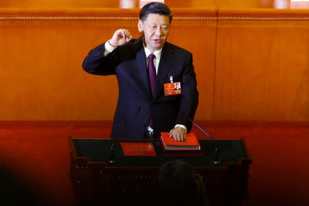 Chinese President Xi Jinping pledges an oath to the Constitution after being confirmed president for another term during the fifth plenary session of the National People's Congress (NPC) at the Great Hall of the People in Beijing, China March 17, 2018. REUTERS/Thomas Peter