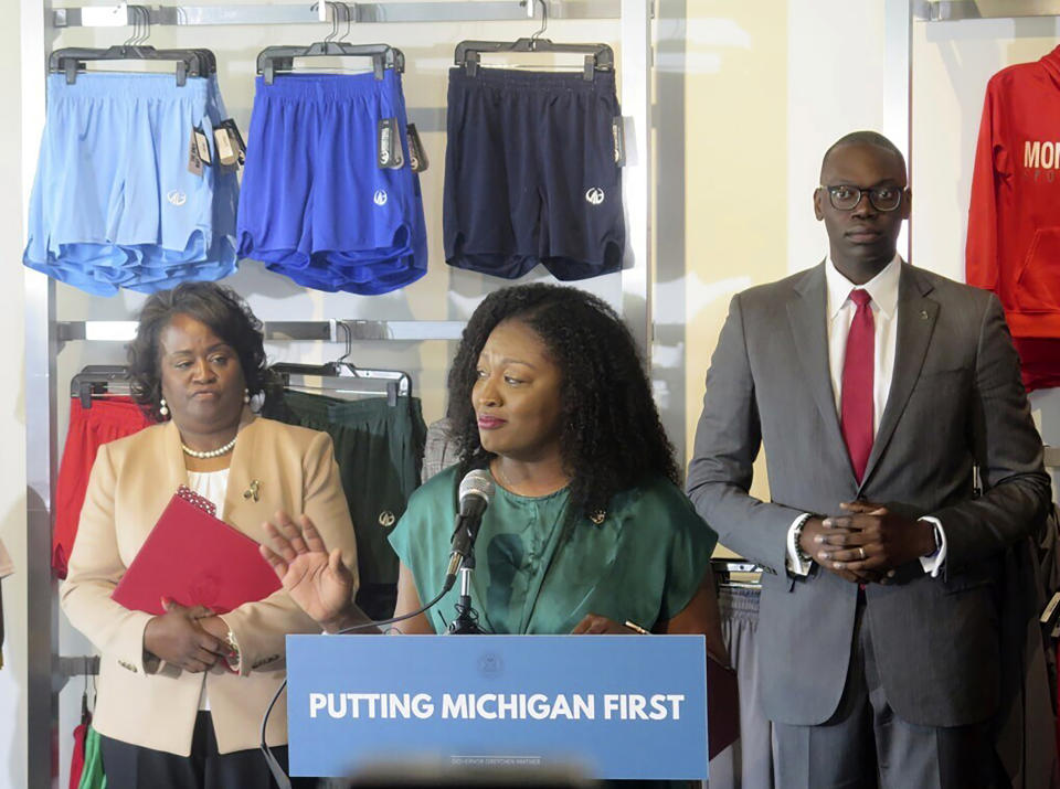 State Sen. Sarah Anthony stands at a podium with plaque that reads: Putting Michigan first