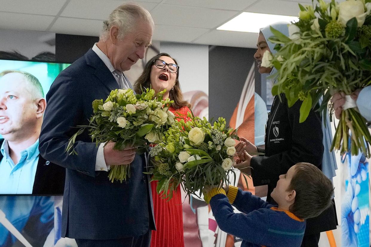 Britain's King Charles III receives flowers as he visits the University of East London to mark the University's 125th anniversary and open a new frontline medical teaching hub on February 8, 2023 in London, England.