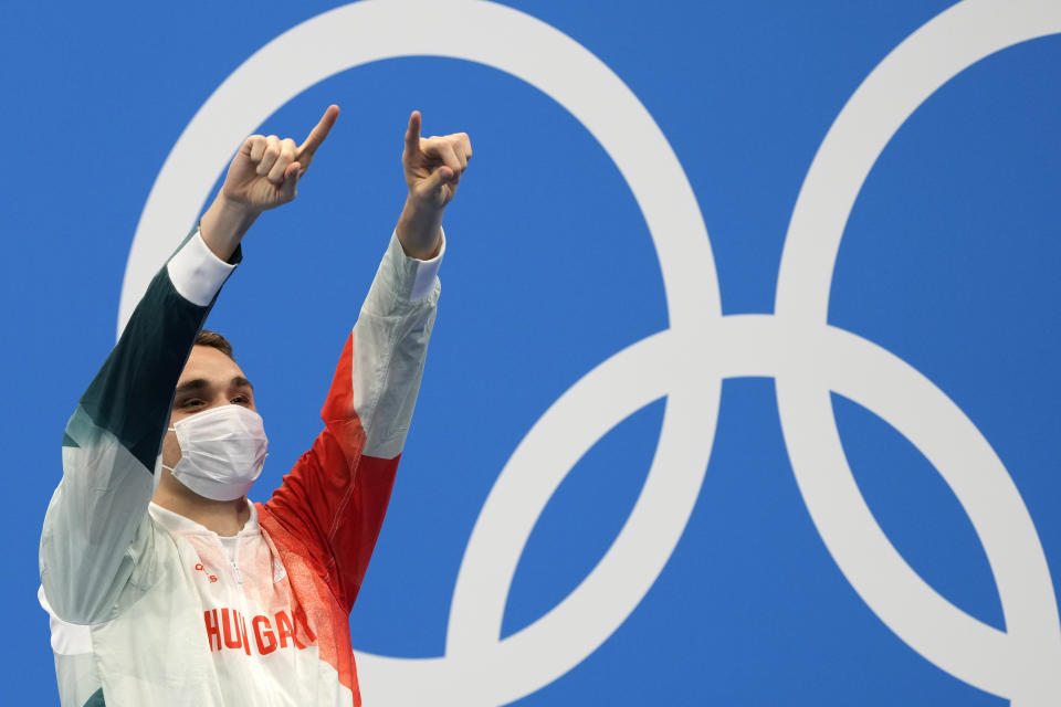 Kristof Milak of Hungary waves on the podium after winning the gold medal in the men's 200-meter butterfly final at the 2020 Summer Olympics, Wednesday, July 28, 2021, in Tokyo, Japan. (AP Photo/Martin Meissner)