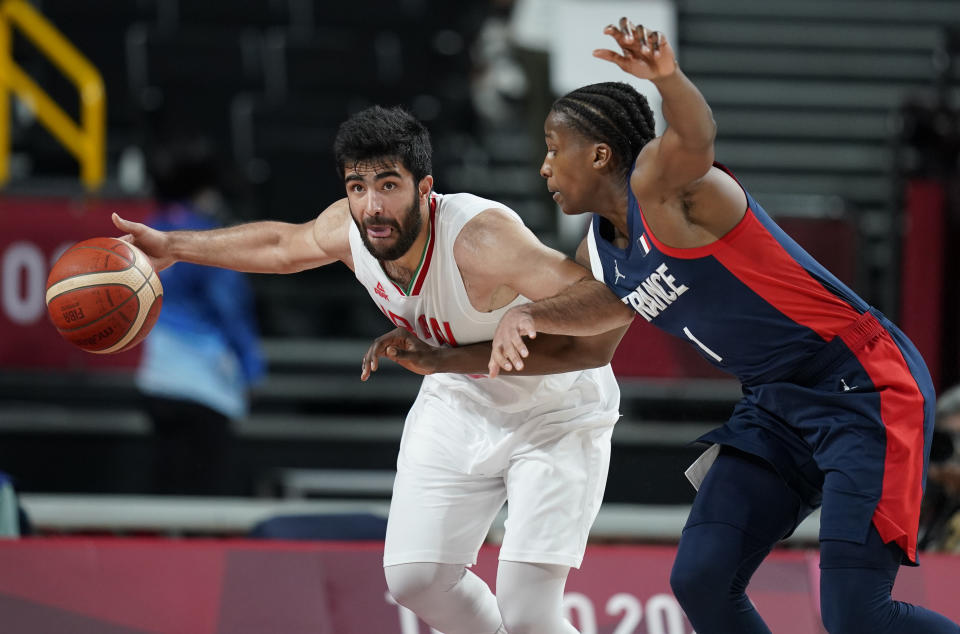 Iran's Behnam Yakhchalidehkordi (88), left, drives past France's Frank Ntilikina (1) during men's basketball preliminary round game at the 2020 Summer Olympics, Saturday, July 31, 2021, in Saitama, Japan. (AP Photo/Charlie Neibergall)