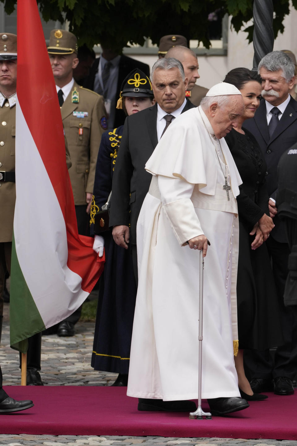 Pope Francis and Hungary President Katalin Novák walk past Hungary Prime Minister Viktor Orban, left, in the square of "Sándor" Palace in Budapest, Friday, April 28, 2023. The Pontiff is in Hungary for a three-day pastoral visit. (AP Photo/Andrew Medichini)