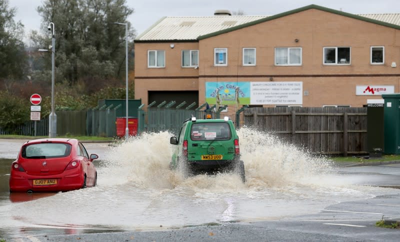 A car circulates in a flooded road in central Rotherham, near Sheffield