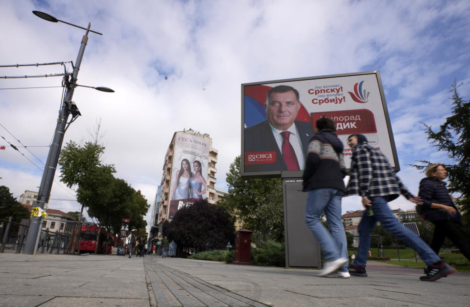 People walk past a pre-election billboard showing Bosnian Serb leader Milorad Dodik in Belgrade, Serbia, Thursday, Sept. 22, 2022. Bosnia has a general election on Oct. 2, in which Dodik is running for the Bosnian Serb presidency. (AP Photo/Darko Vojinovic)