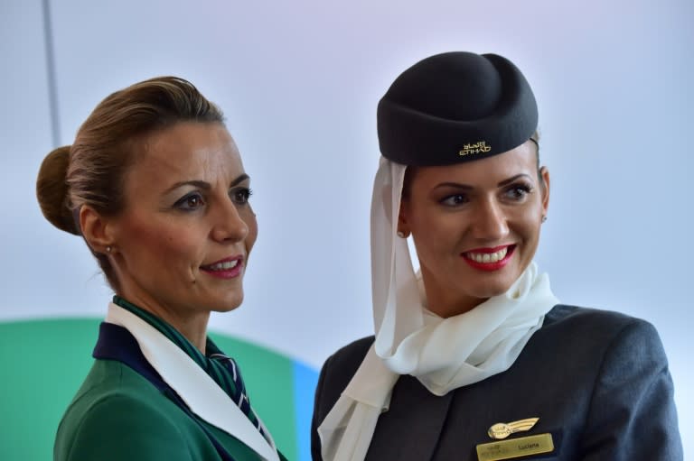 Hostesses of Italian company Alitalia (L) and Etihad Airways are pictured during a press conference to announce the partnership between Alitalia and Etihad in 2014