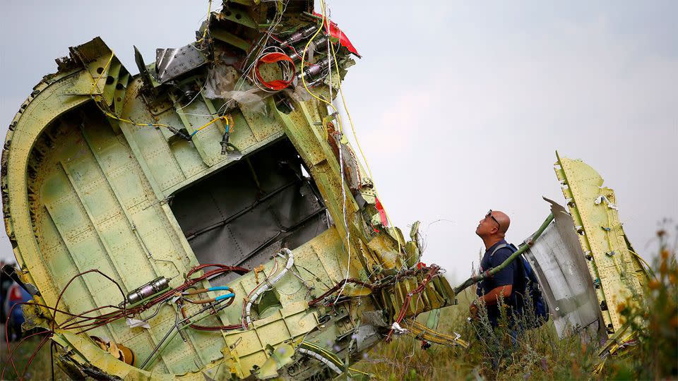 A Malaysian air crash investigator inspects the crash site near the village of Hrabove. Photo: REUTERS/Maxim Zmeyev