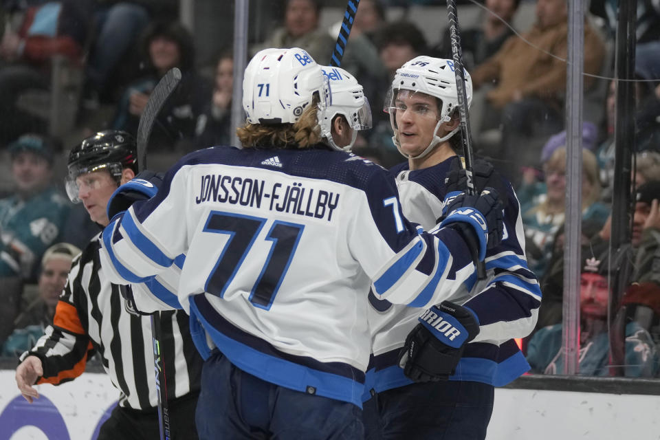Winnipeg Jets center Morgan Barron, right, is congratulated by left wing Axel Jonsson-Fjallby (71) and center Dominic Toninato after scoring against the San Jose Sharks during the second period of an NHL hockey game in San Jose, Calif., Thursday, Jan. 4, 2024. (AP Photo/Jeff Chiu)