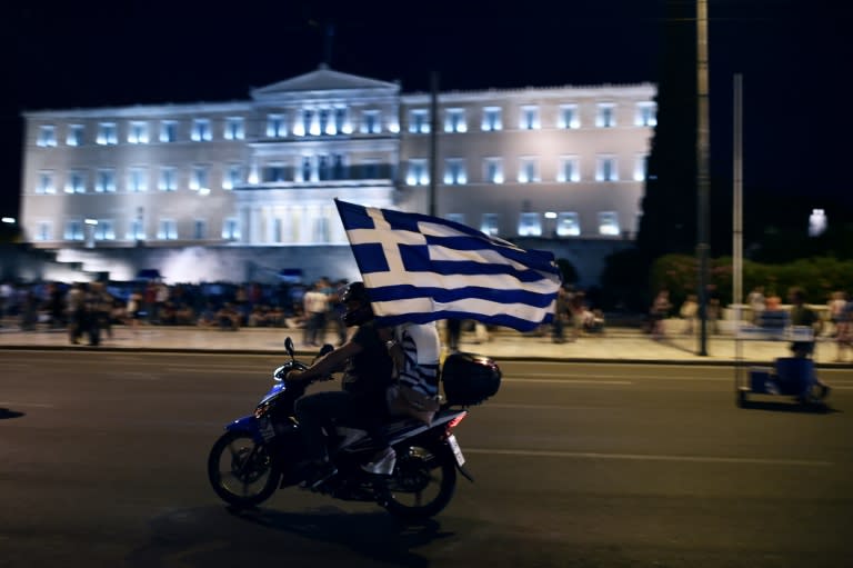 A motorcylist celebrates with a Greek flag in Athens on July 5, 2015 as the country voted to reject more austerity terms demanded by creditors in exchange for bailout funds