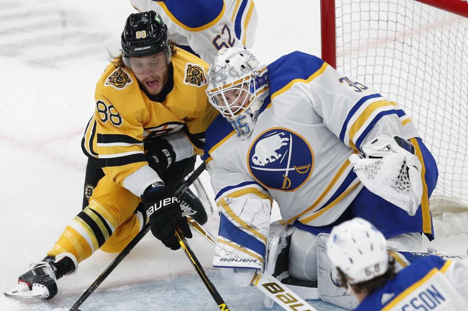 Boston Bruins' David Pastrnak (88) tries to get a shot on Buffalo Sabres' Linus Ullmark (35) during the first period of an NHL hockey game, Saturday, March 27, 2021, in Boston. (AP Photo/Michael Dwyer)
